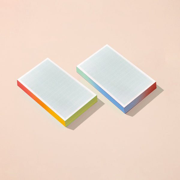 Moglea Grid Grid Pad notepad with lined grid pages, showing the side view with a soft cover and spiral binding.