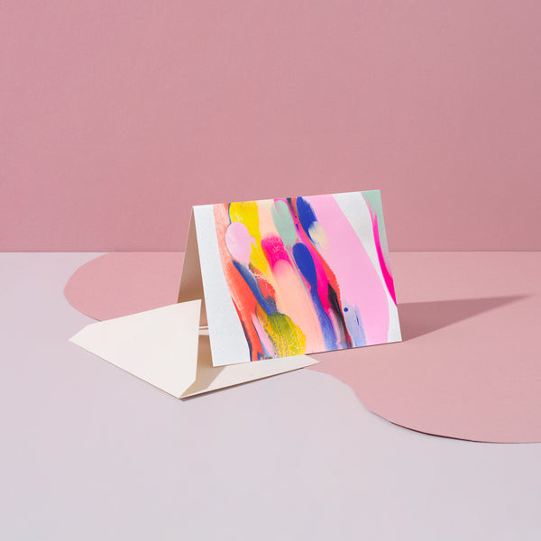Colorful rainbow swirl stationery set by Moglea, featuring notebooks, pens, and paper in vibrant rainbow patterns.